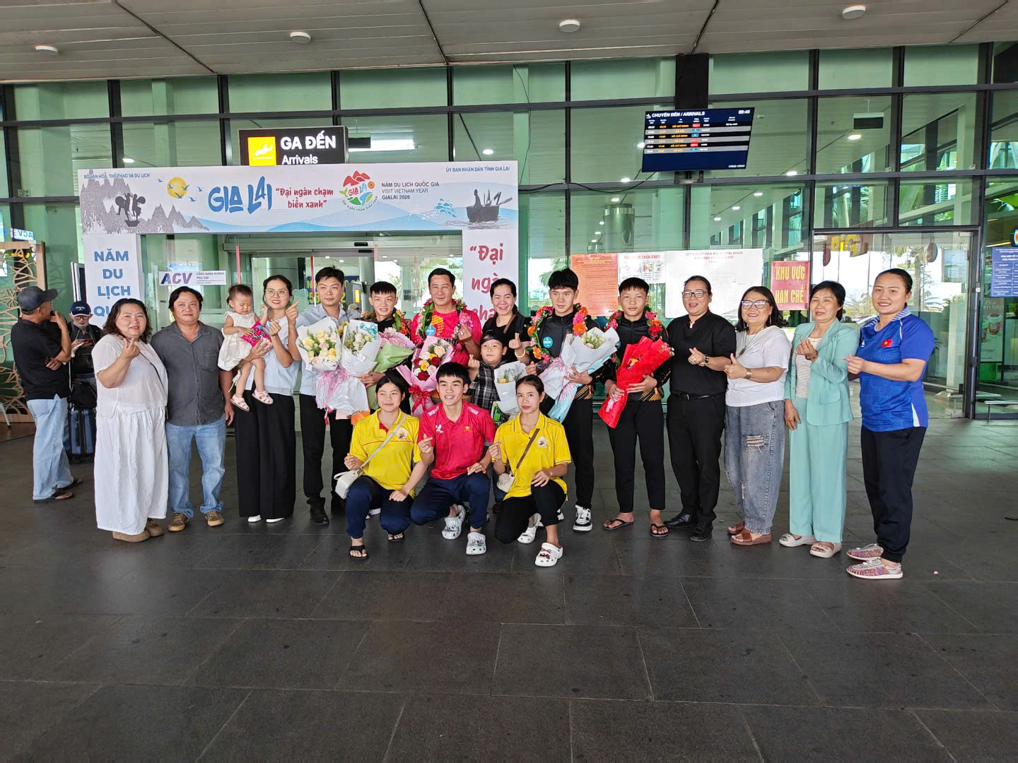 HLV Trần Đình Đô và các học trò nhận hoa chúc mừng tại sân bay Phù Cát
